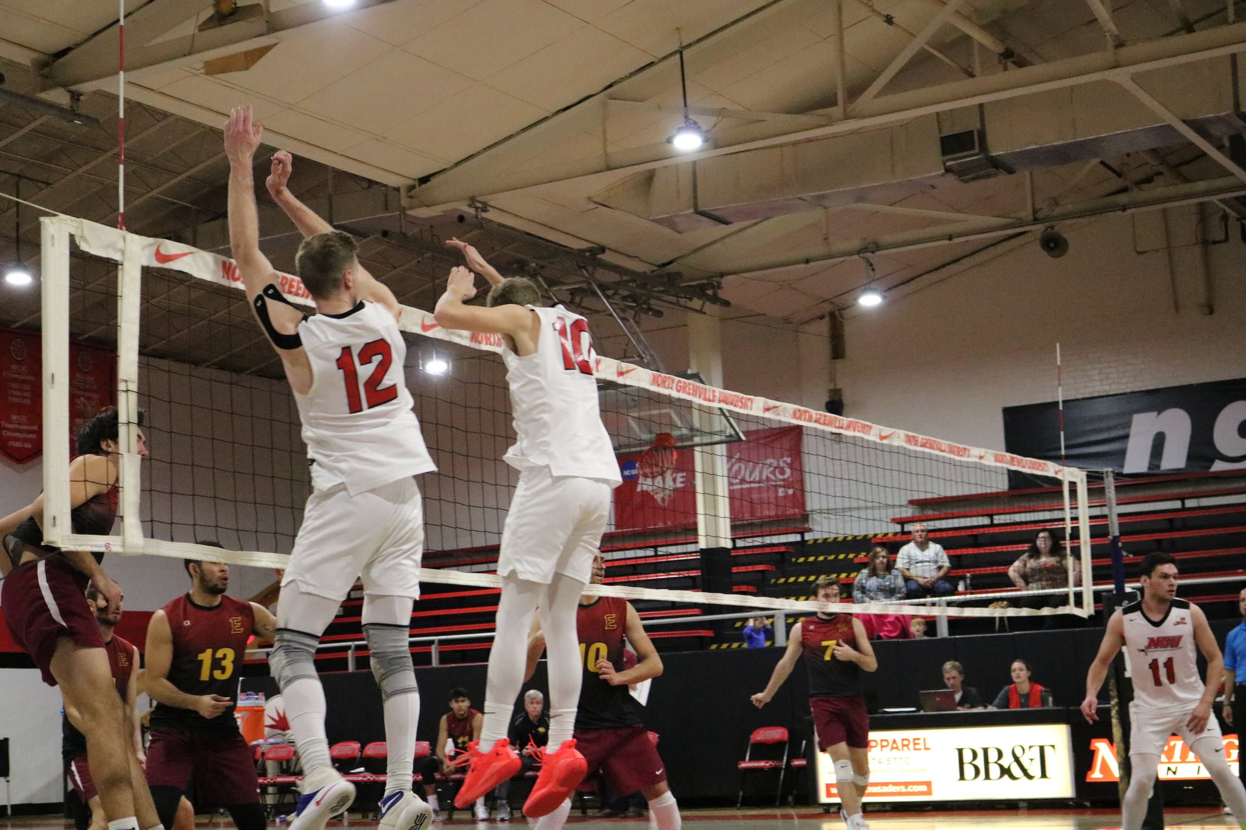 Baker (10) and Campbell (12) jump to block the ball being hit by the Lions during the third set.