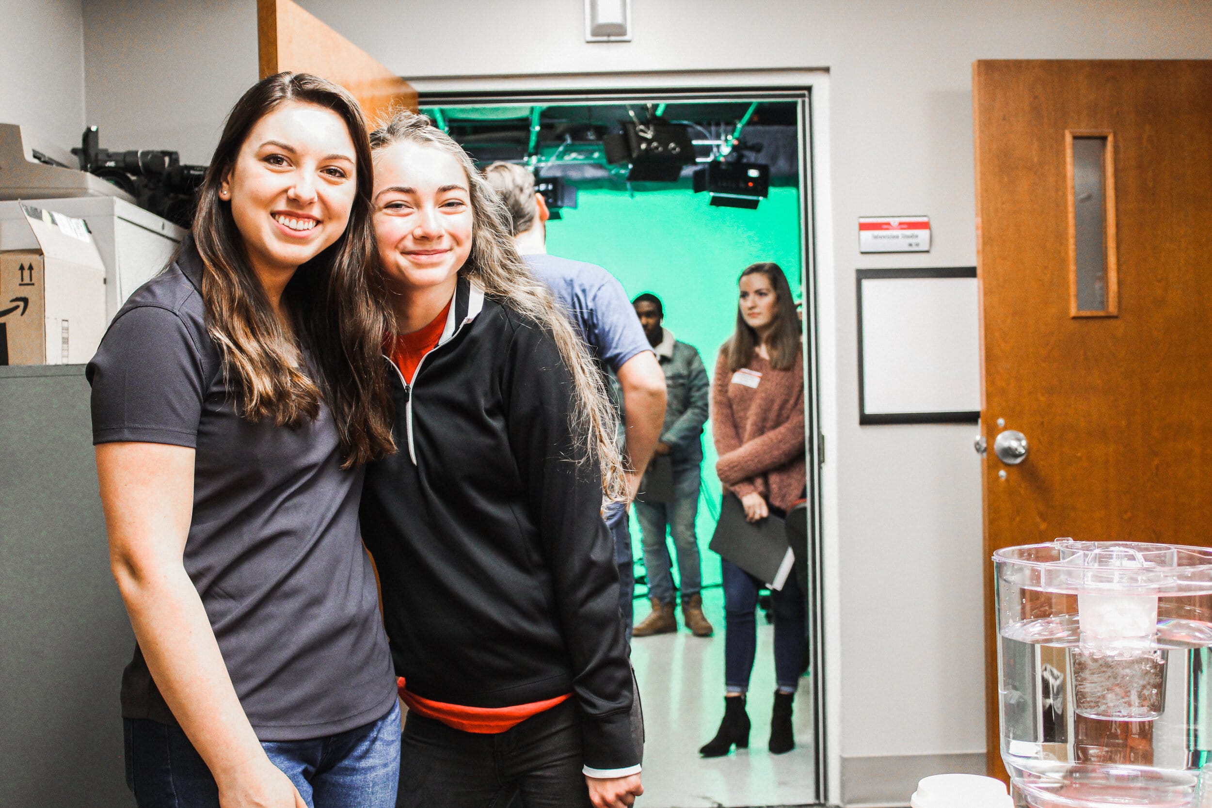 Lauren Dibble (junior) and Victoria Murphy (freshman) welcoming students in the Mass Comm Department.