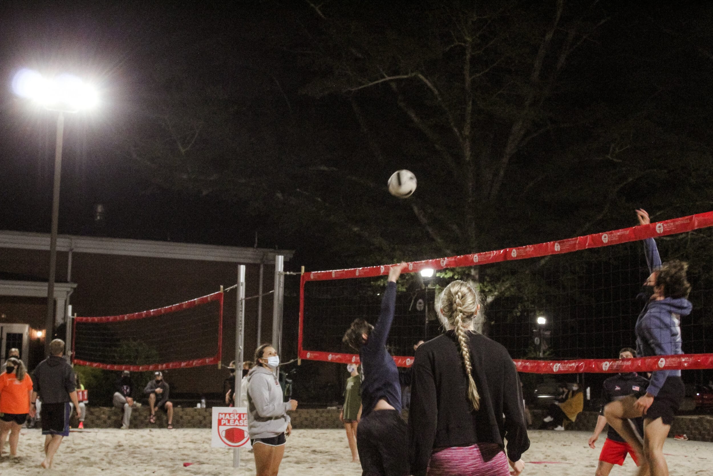 The ball is being spiked over the net. Opponents are preparing to return the pass.