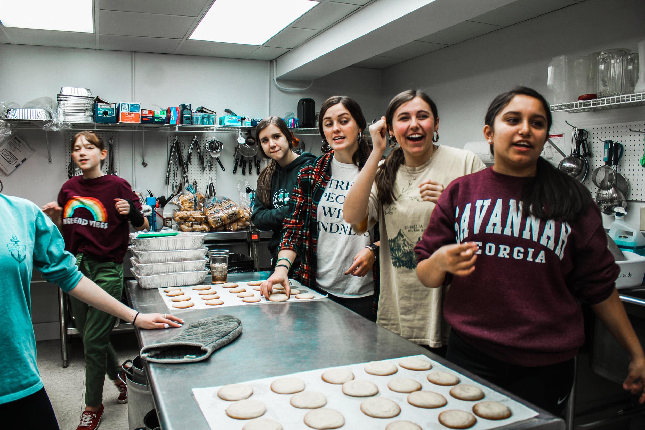 Youth students alongside Chely Dickert (freshman) and Claire Hill (senior) making cookies.