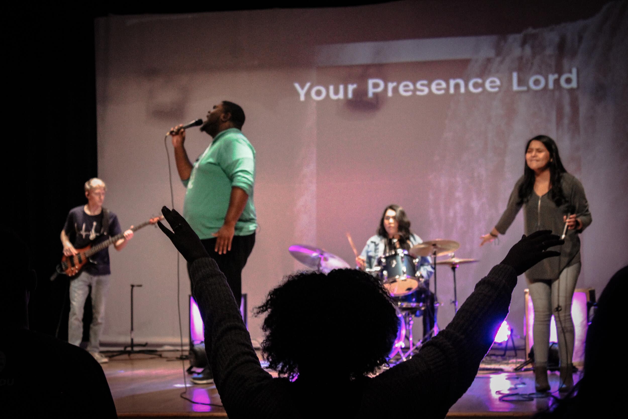 A student raising her hands during the performance of Holy Spirit by Jesus Culture.
