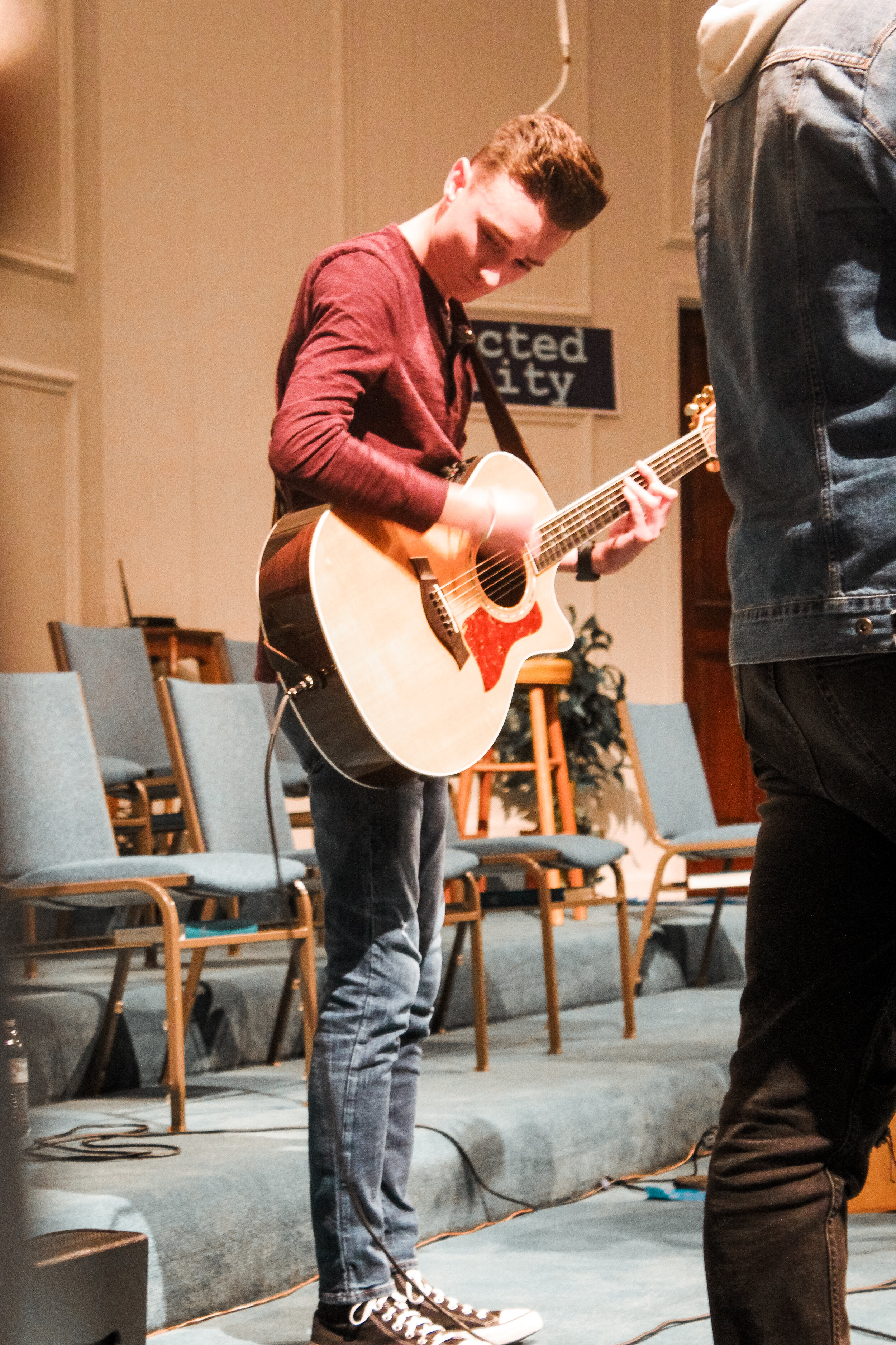 Sophomore Bryson Meece plays acoustic guitar while leading worship with the BCM band.