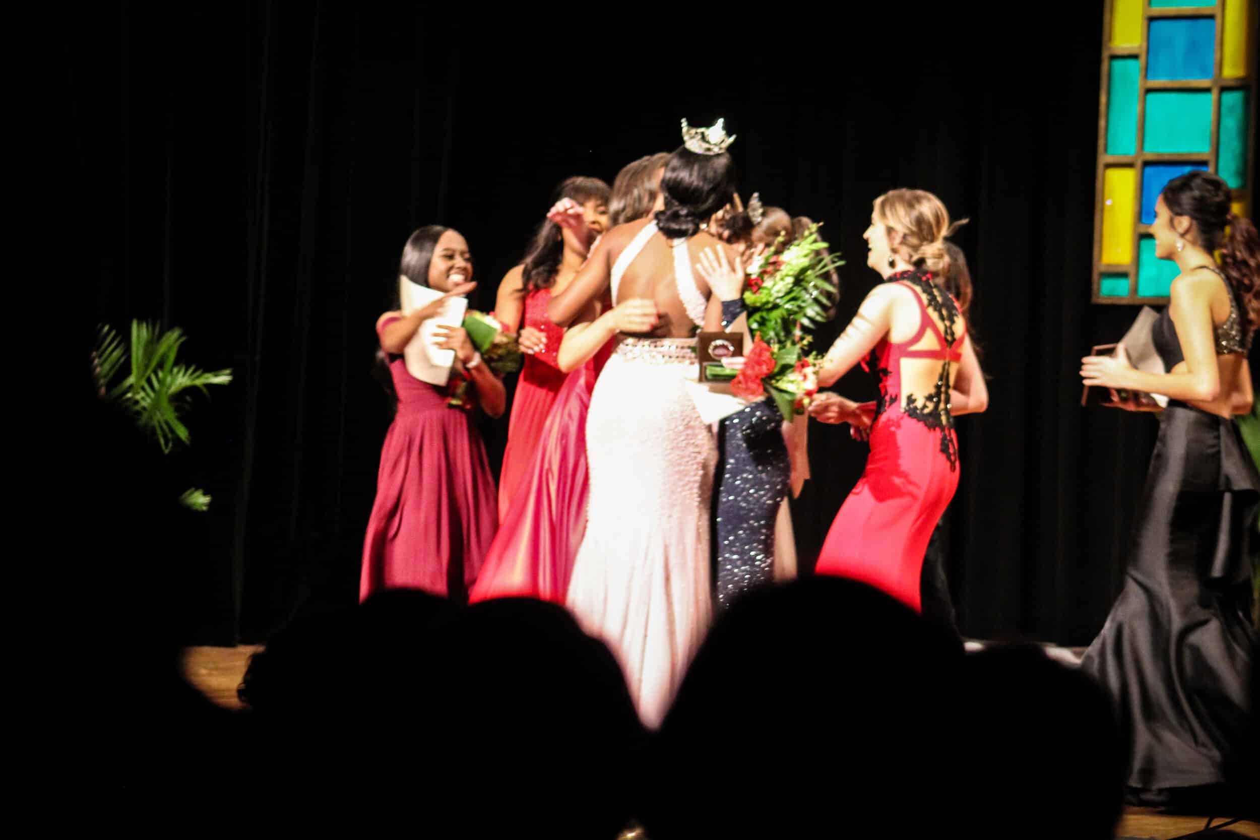 Contestants hugging on stage after Miss NGU is announced.