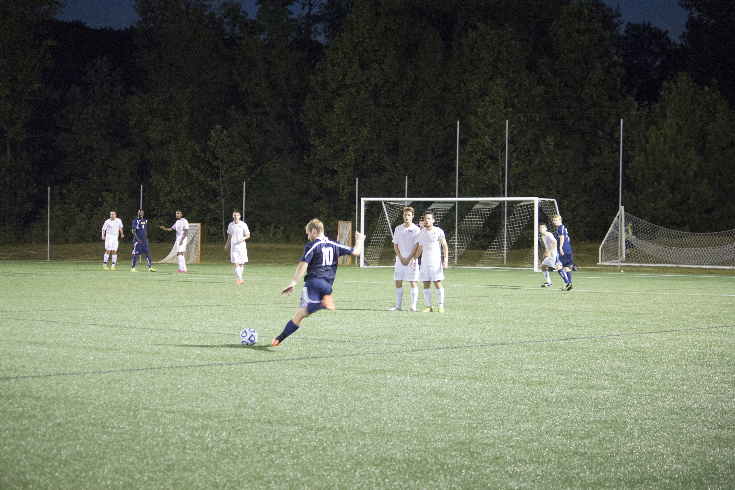  Two teammates line up to form a wall against player #10's free kick. 