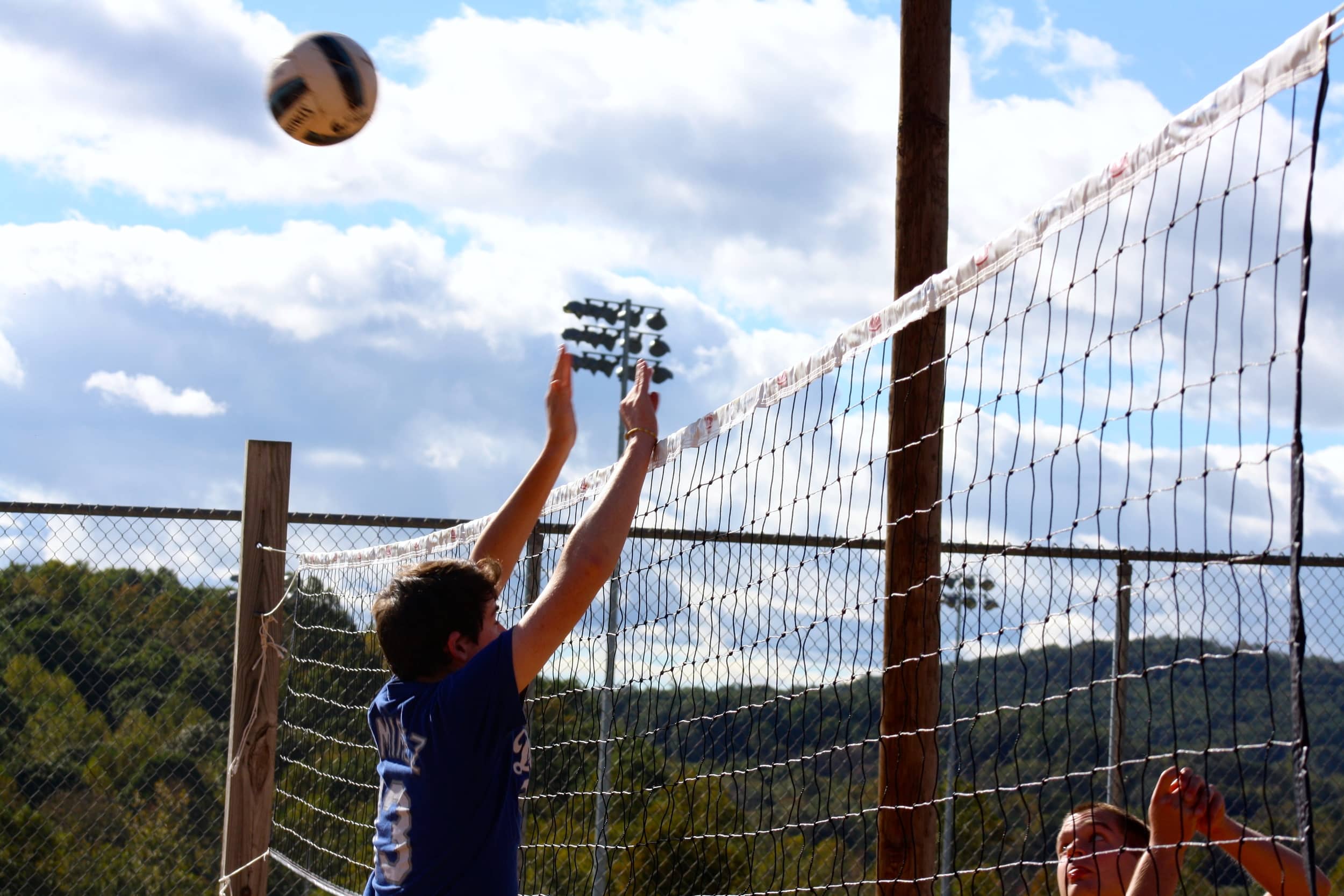  A student attempts to block the ball from his team's side of the court. 