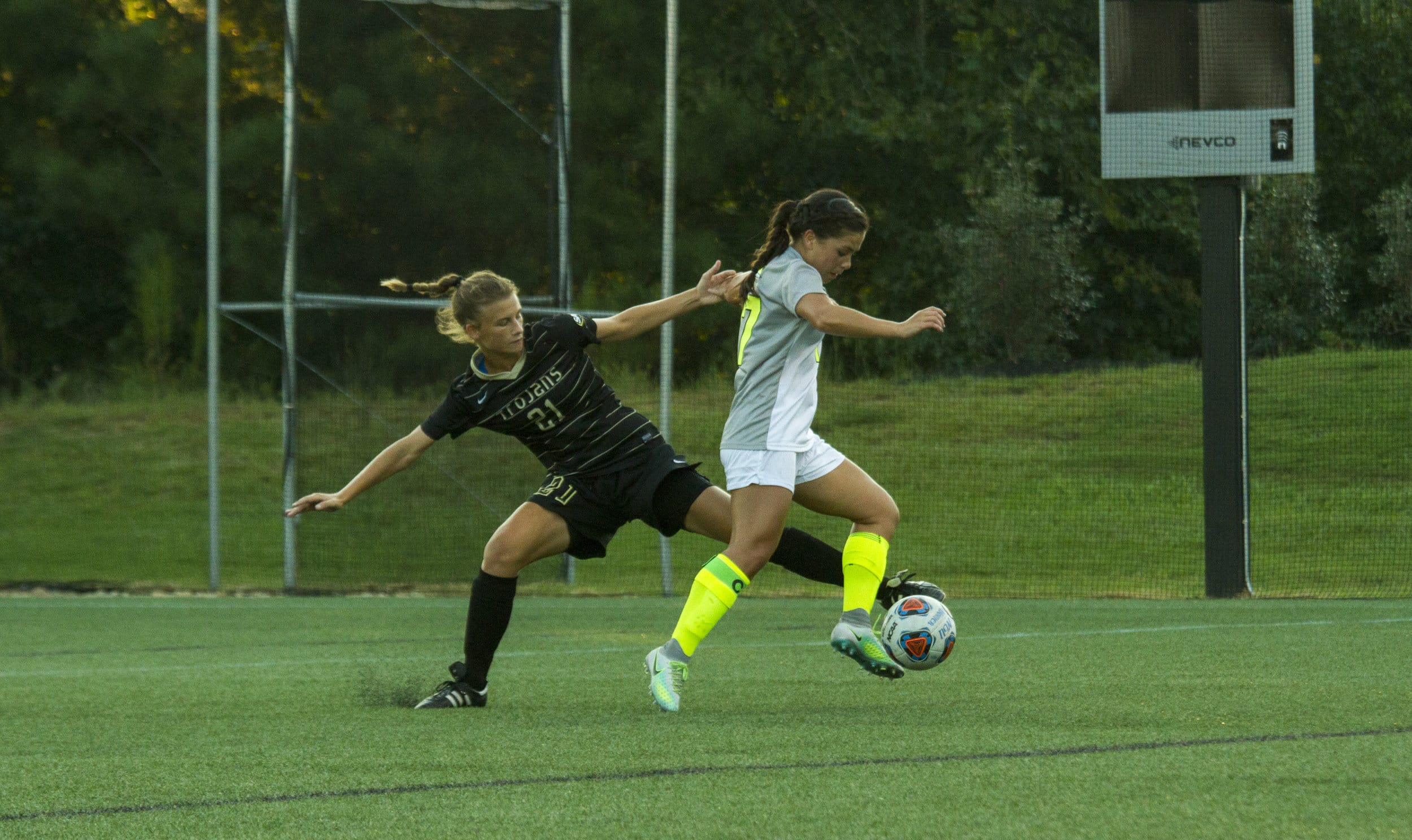  Senior Megan Robertson gets past rival Trojans player despite the attempt she made to steal the ball from Robertson.&nbsp; 