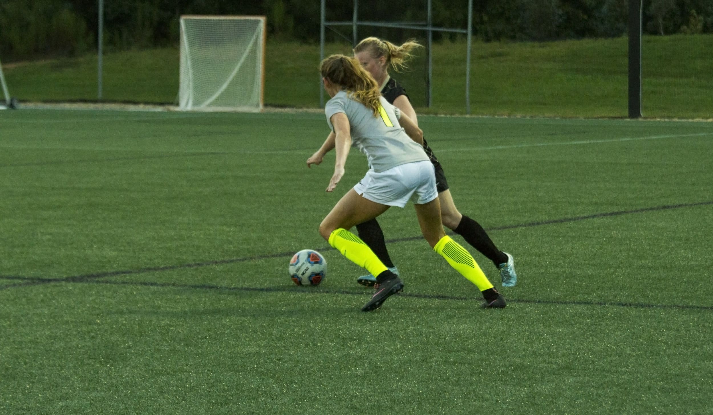  Senior Lindsay Tuten challenges rival Trojans player to win the ball back for the Crusaders.&nbsp; 