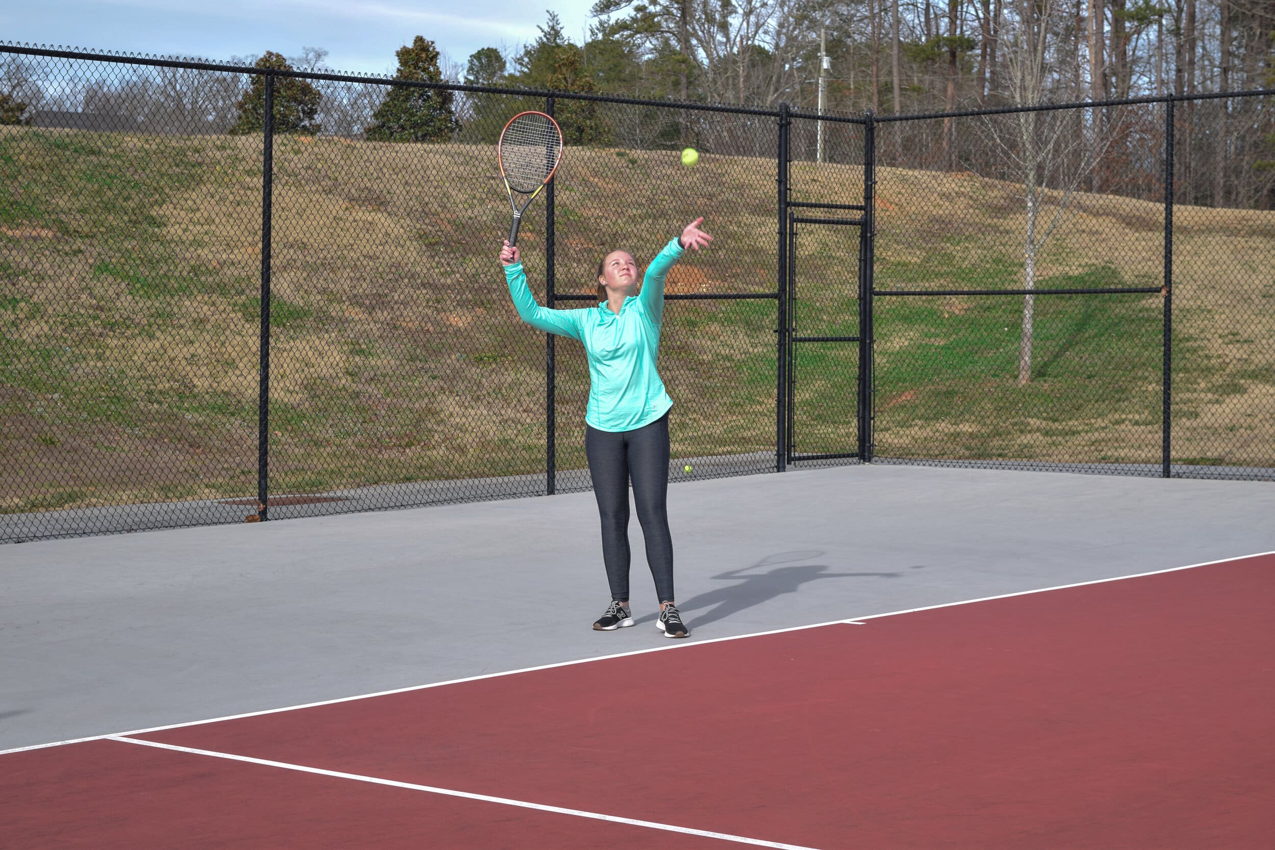 Morgan takes a swing at tennis practice.