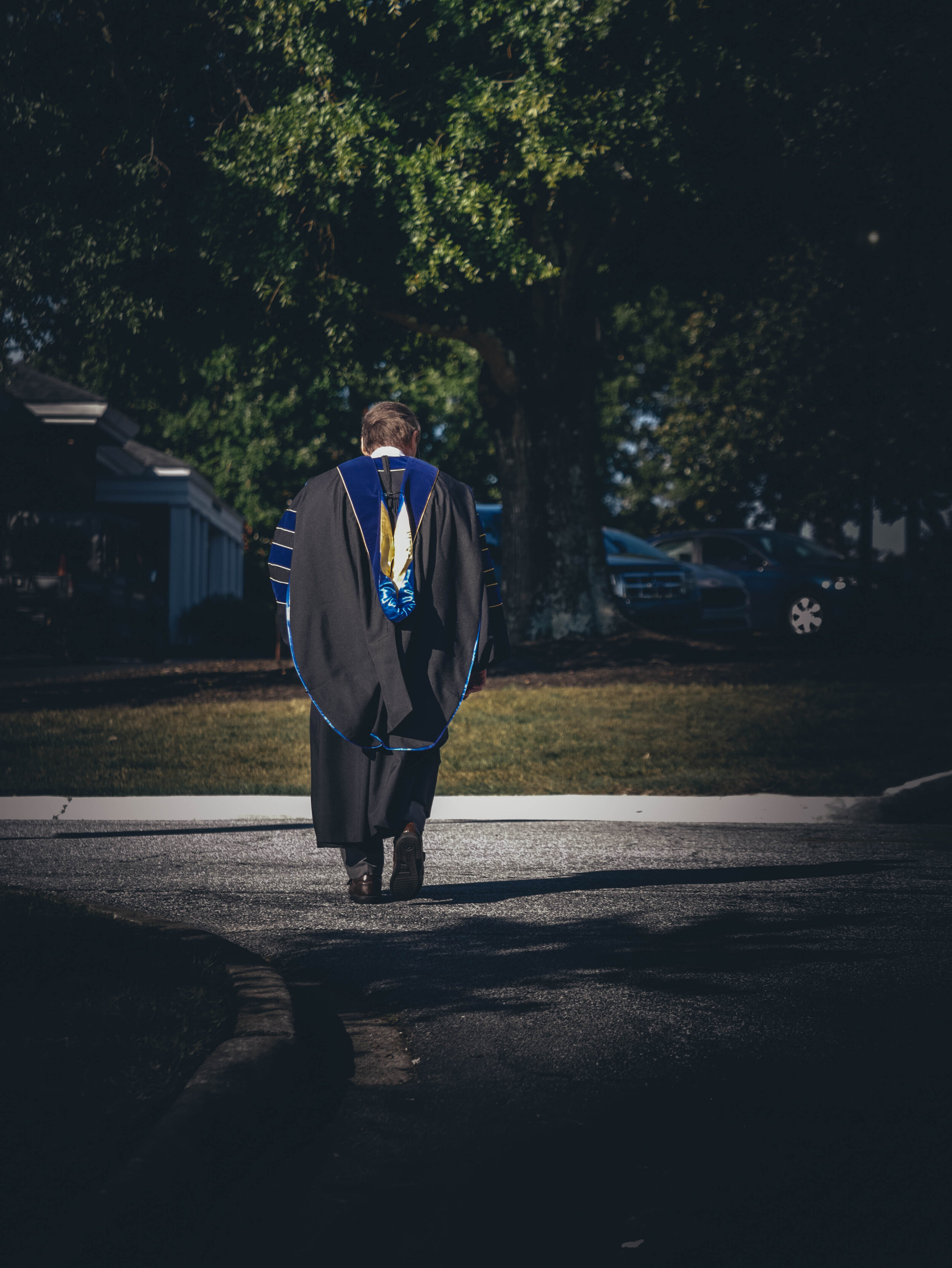 A professor dressed in his robe walks towards the chapel.