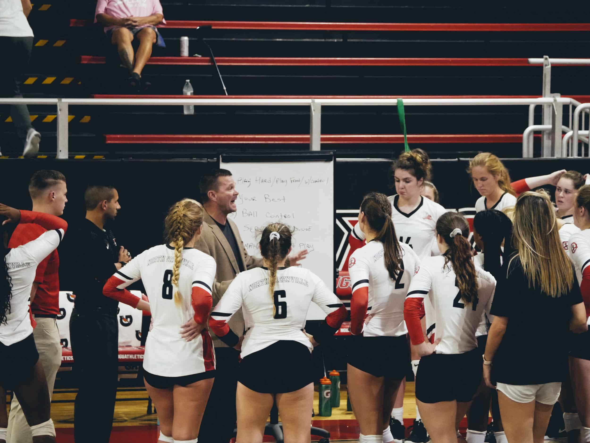 Trailing in the second set coach Greg Mosley gives the Crusaders a quick pep talk.