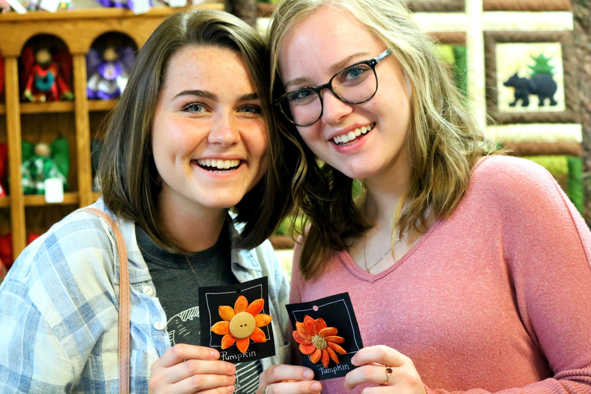 Ruthie Evans, sophomore elementary education major and Tara Madeira, sophomore education major hold little pins made out of pumpkin seeds. These can be found at the Carolina Mountain Artist Guild in Hendersonville, N.C.
