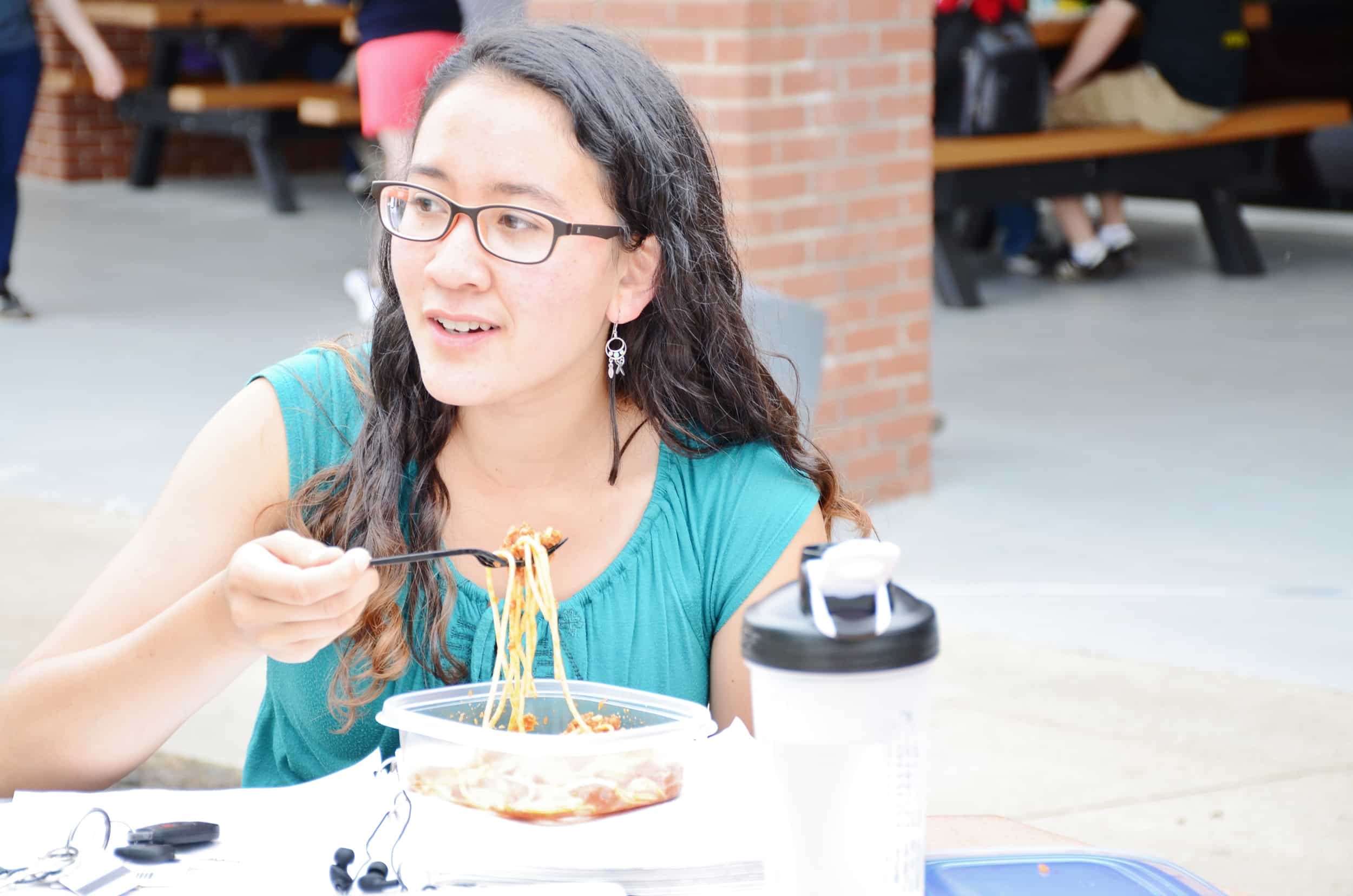 Alisa Sandlin enjoys her meal while watching other students engage in field activities.&nbsp;