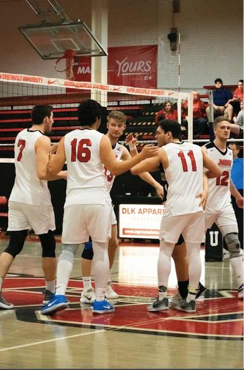 Junior Ben Hamsho (13) is congratulated by his teammates after scoring a point.