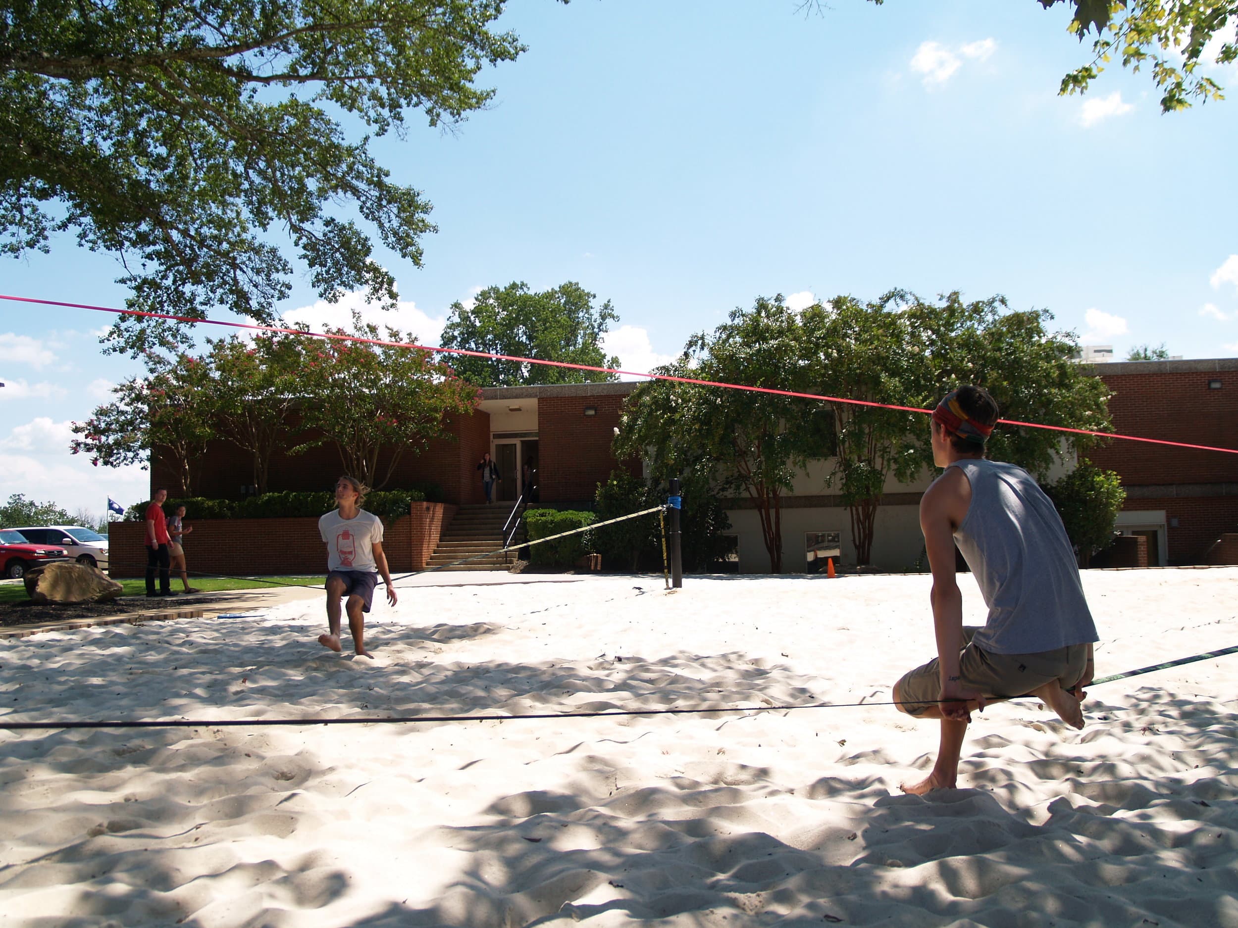   Students relax and enjoy the new slack lining area on a sunny afternoon.&nbsp;  