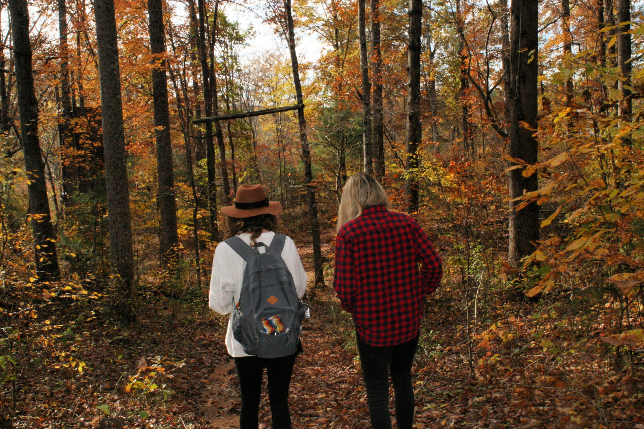 Sophomores, Courtney Chestnut and Katelyn Benfield hike through the woods at North Greenville University to look for a spot to shoot.
