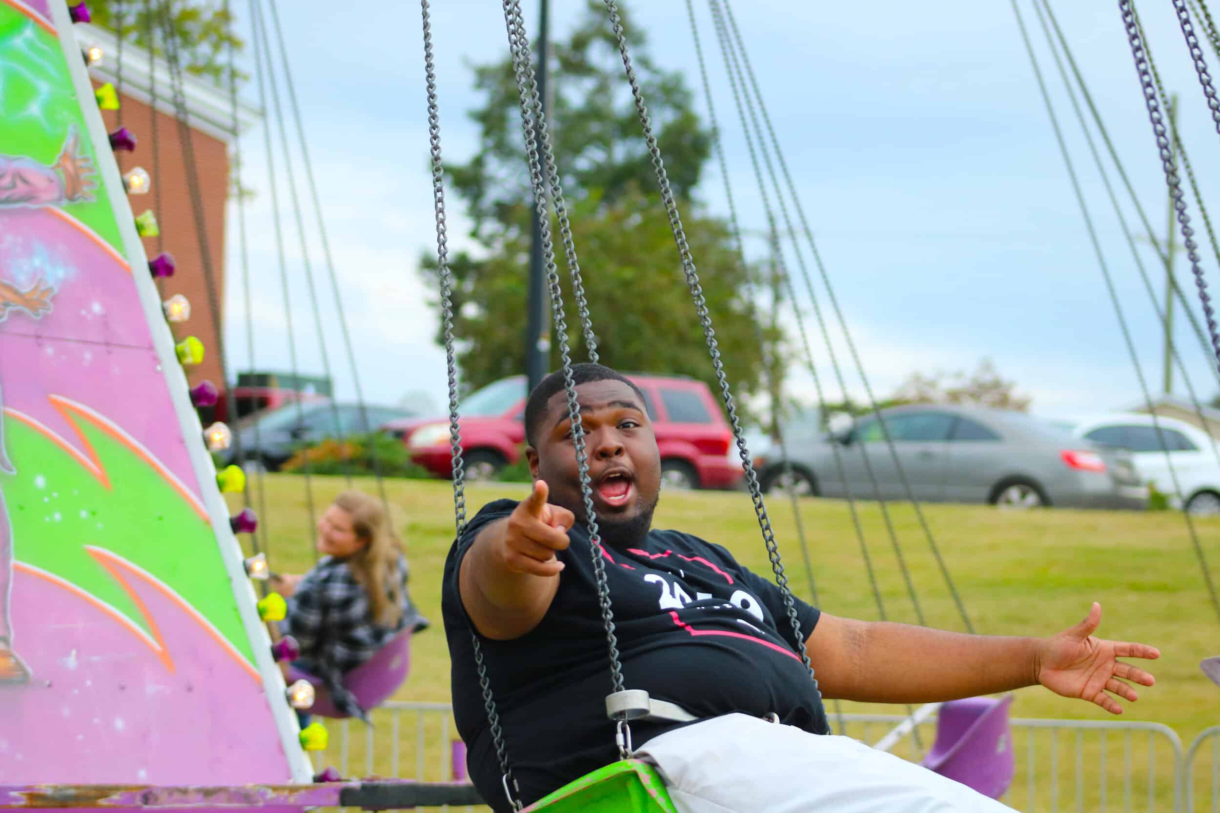 Sophomore Paul Scotland is one of the first people to try out the swings at the Fall for Tigerville fair.