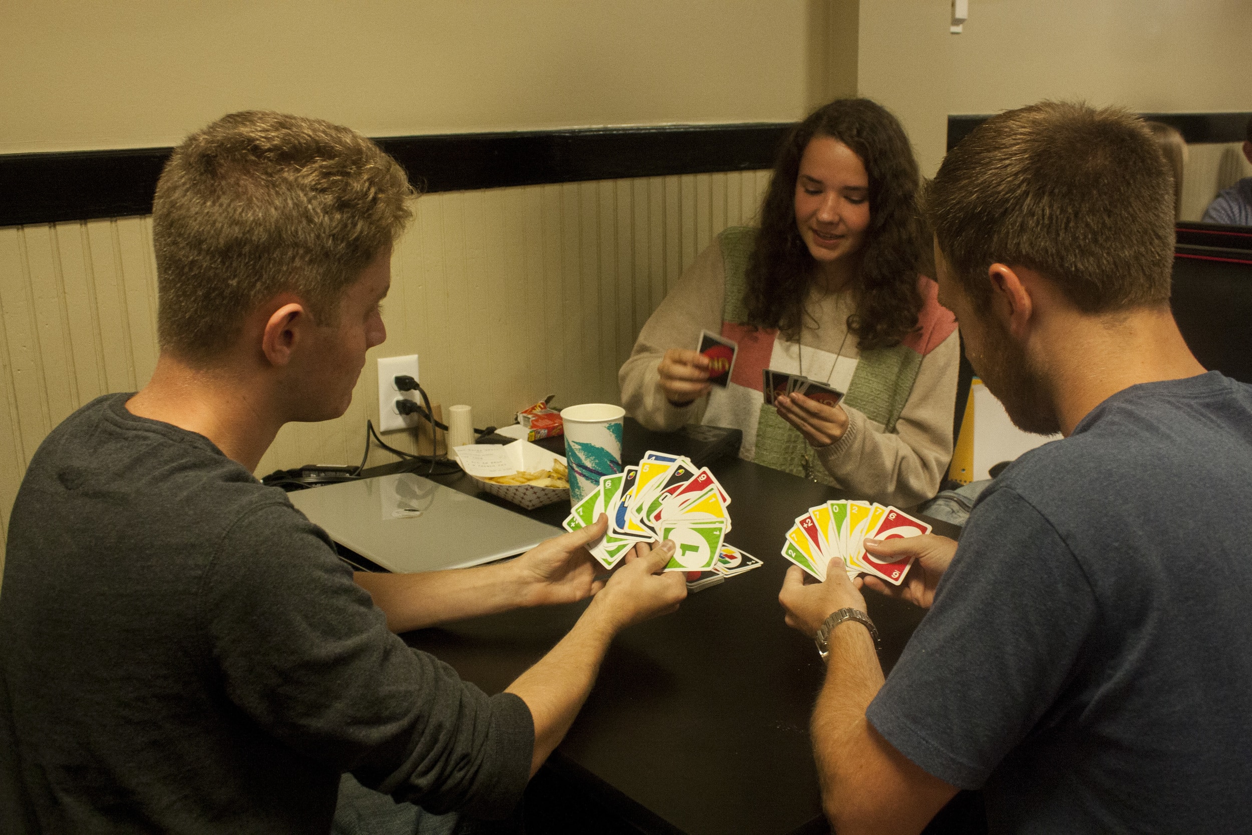 Wes Wessinger, junior, Bethany Stickley, sphomore, and Brandon Lee, junior, hang out in the stud playing a game of cards.