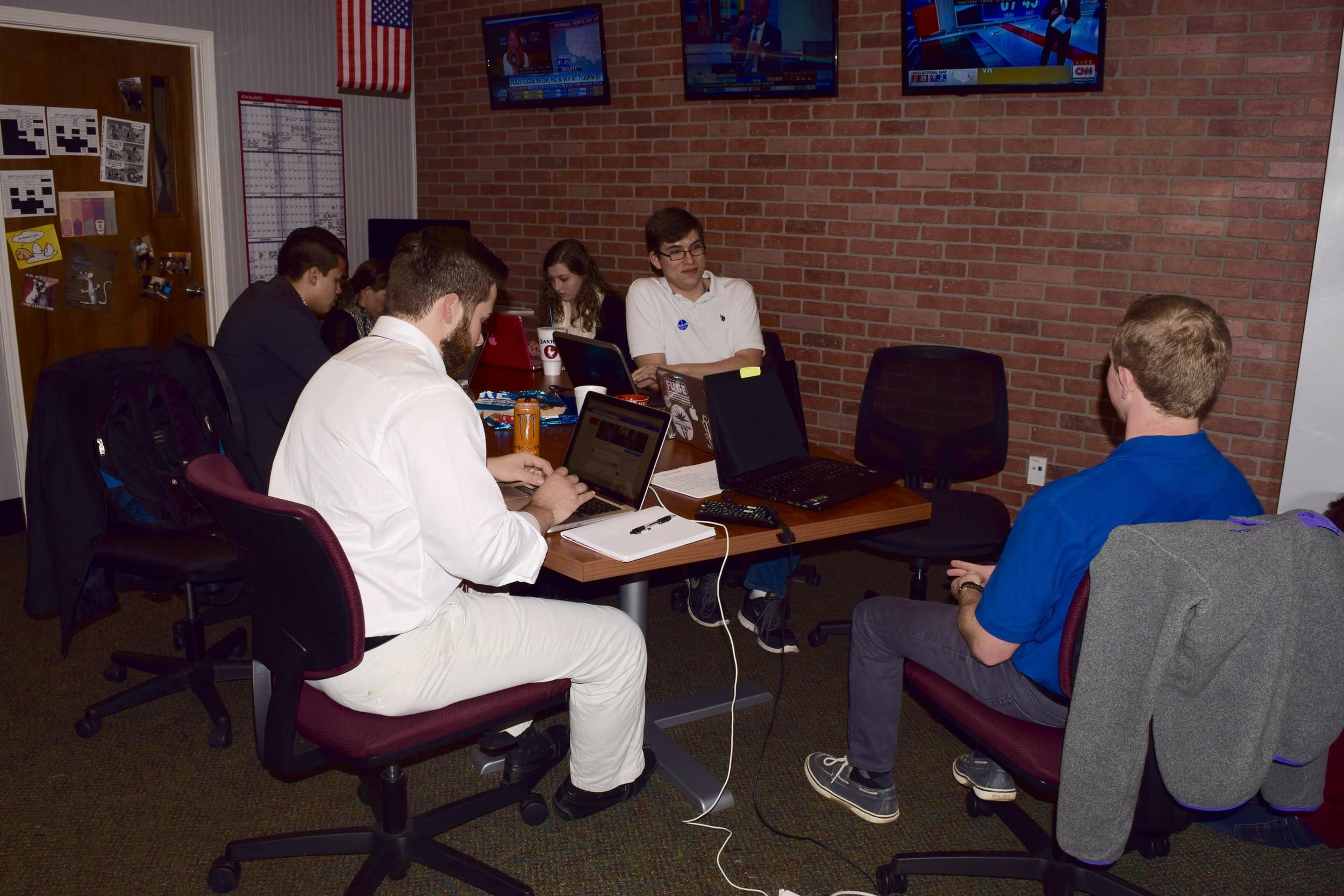 Students work diligently for the Vision Online as the election results are coming in.