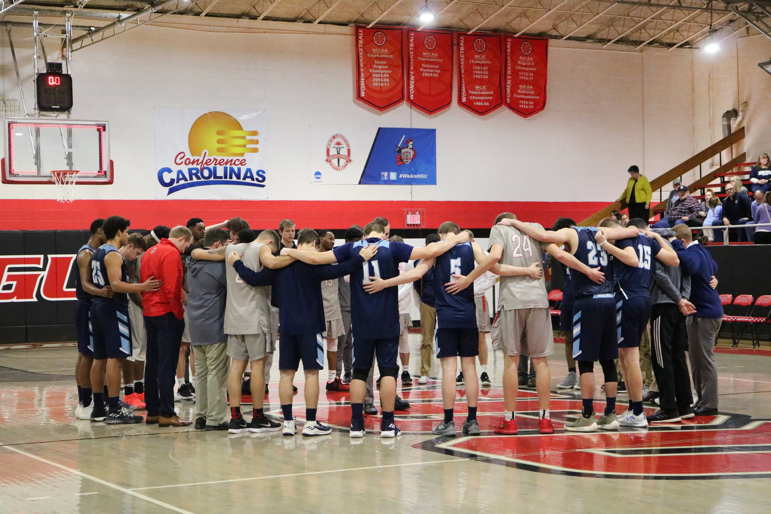 The North Greenville Crusaders and the Bob Jones Bruins circle up for a word of prayer after NGU defeats the Bruins 72-64.