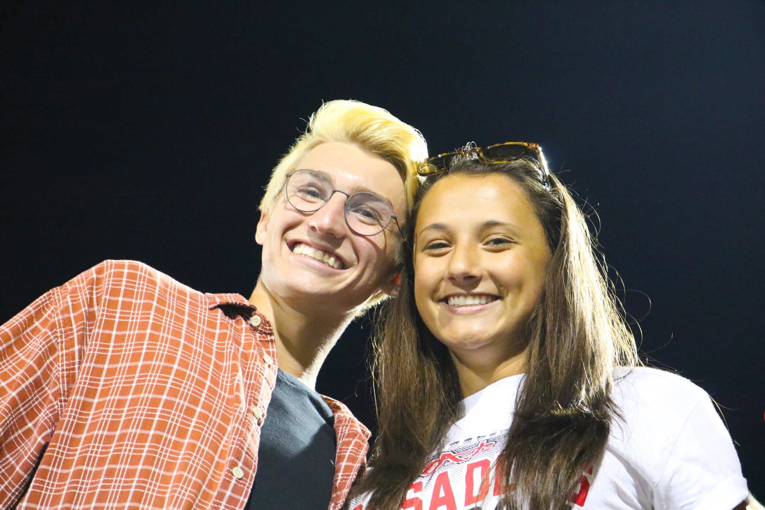Sophomore Jacob Holcombe and junior Millie Klefsaas smile on the sidelines for a quick picture during the second quarter.