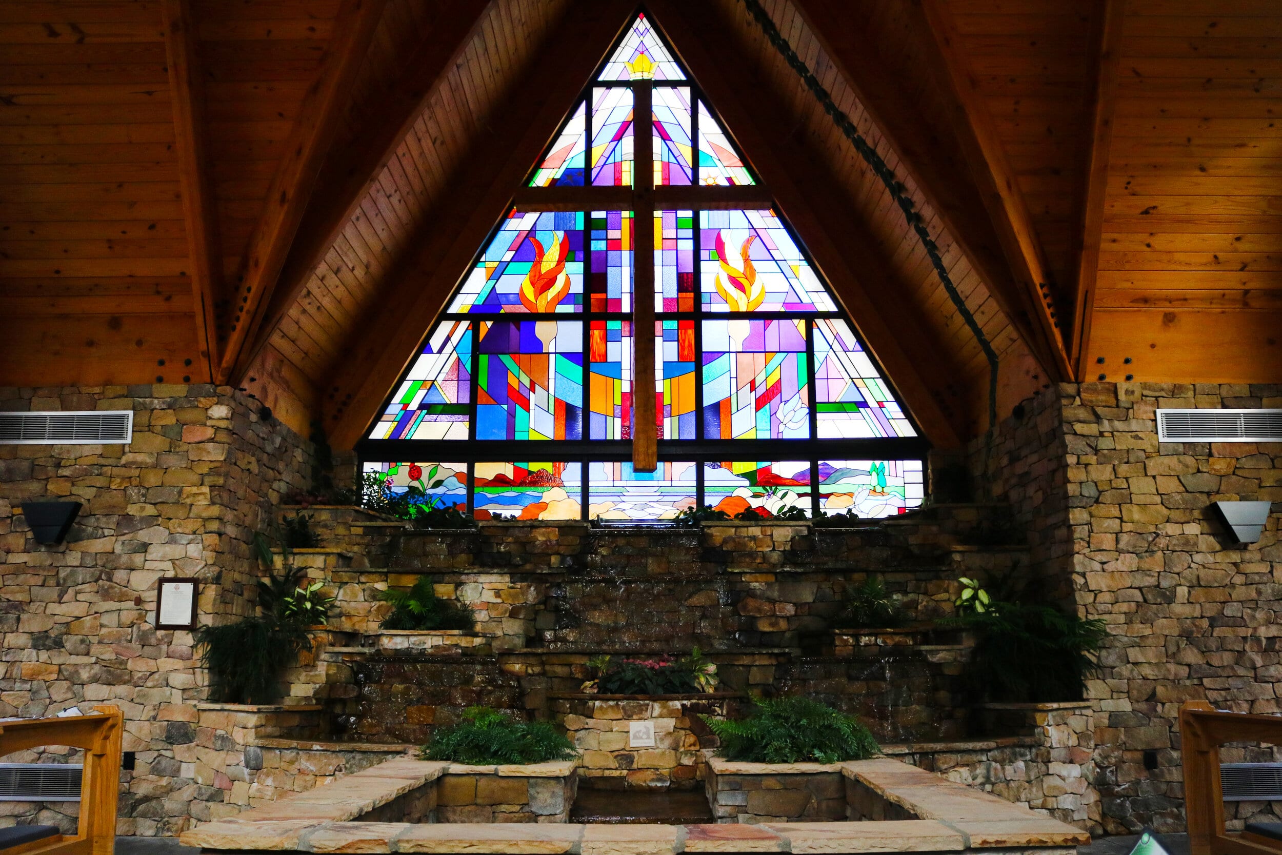 The north wall with the stained glass window, as well as the rock wall with the waterfall.