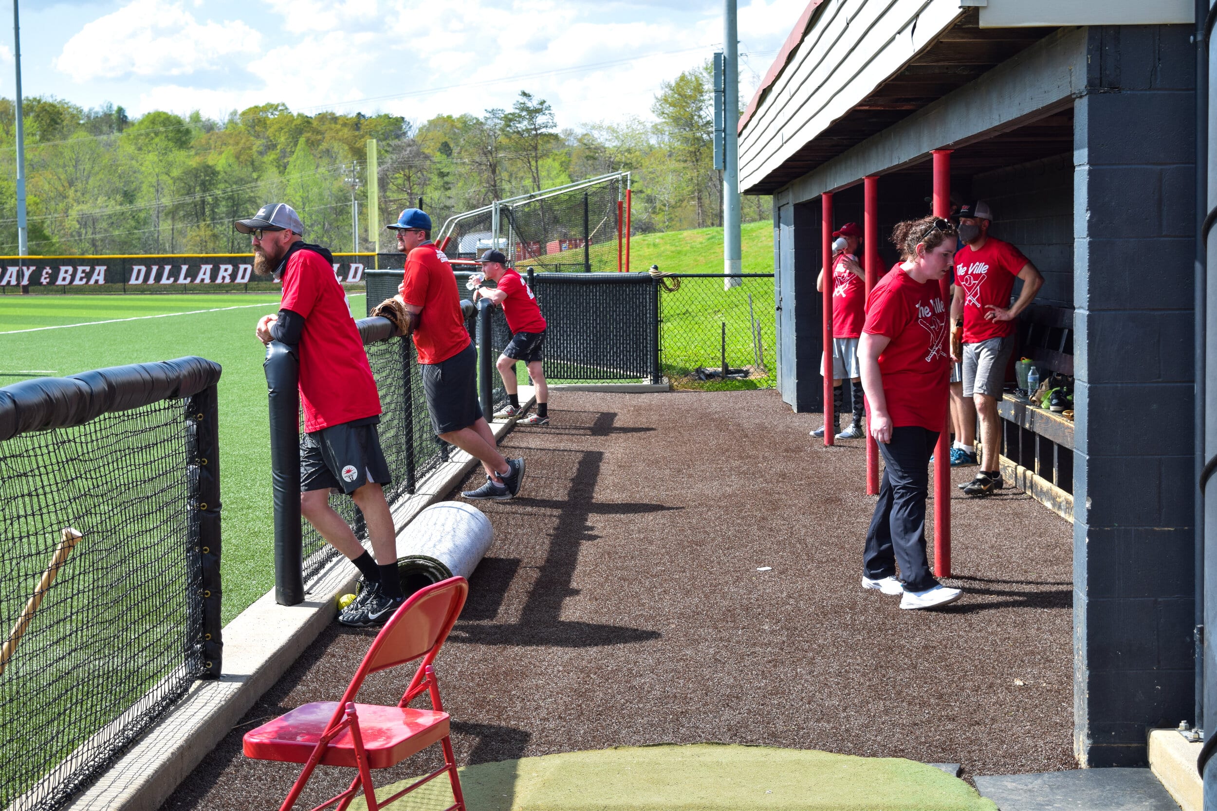 Some of the faculty members watch their teammates from the dugout.