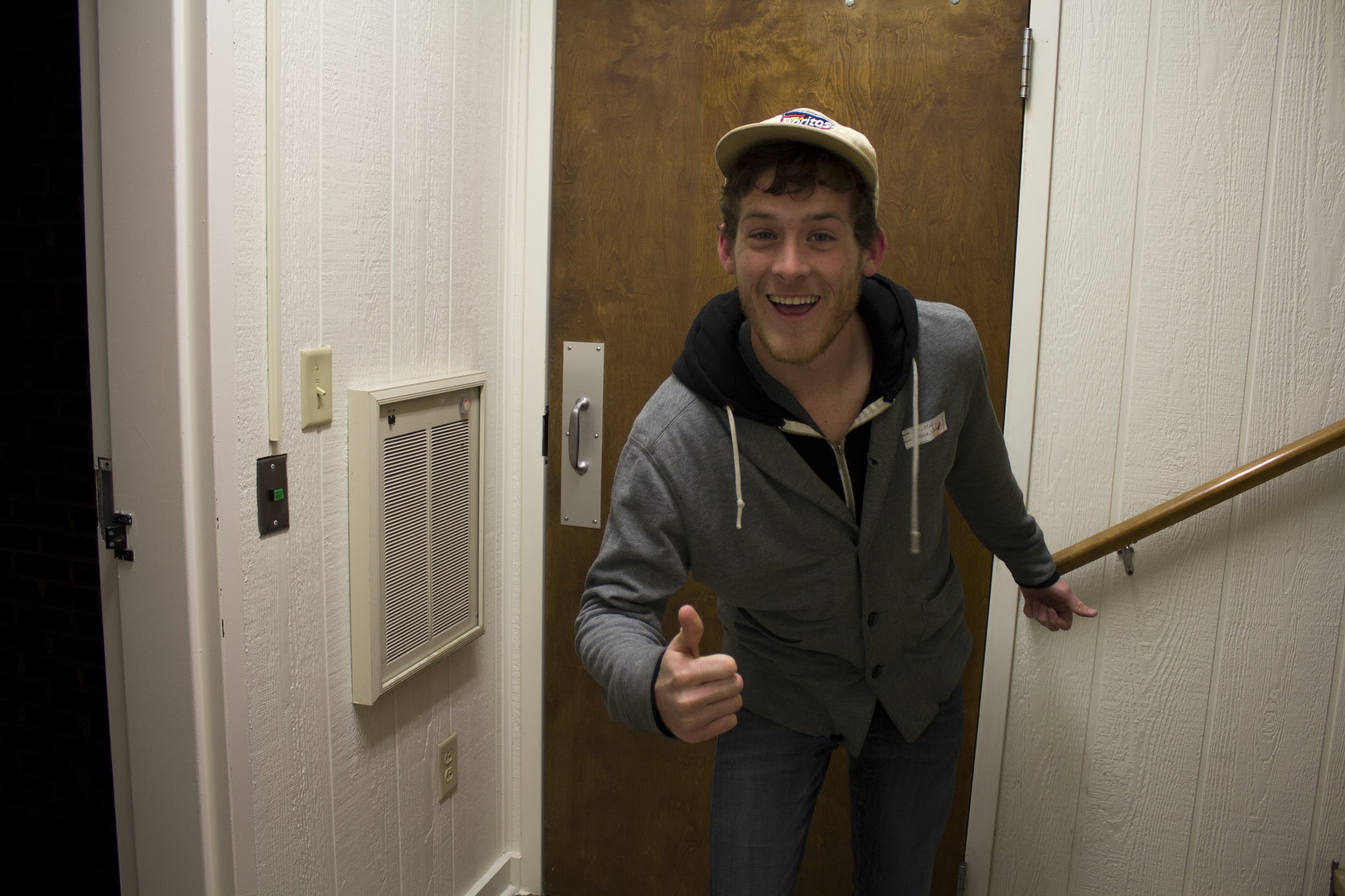  Junior Tyler Ezsol gives his thumbs up approval on the open dorm evening on his way to visit some friends down the hall.&nbsp; 